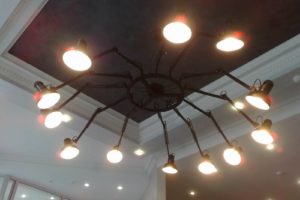 Установка крупной шарнирной люстры в зале элитного интерьерного салона