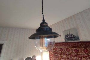 Установка стилизованного под старину подвесного светильника в одной из комнат квартиры